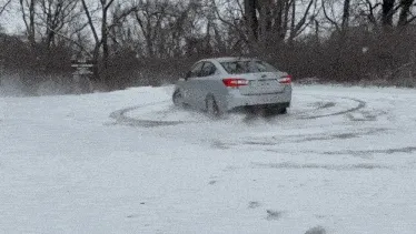 A sedan rocking donuts in the snow